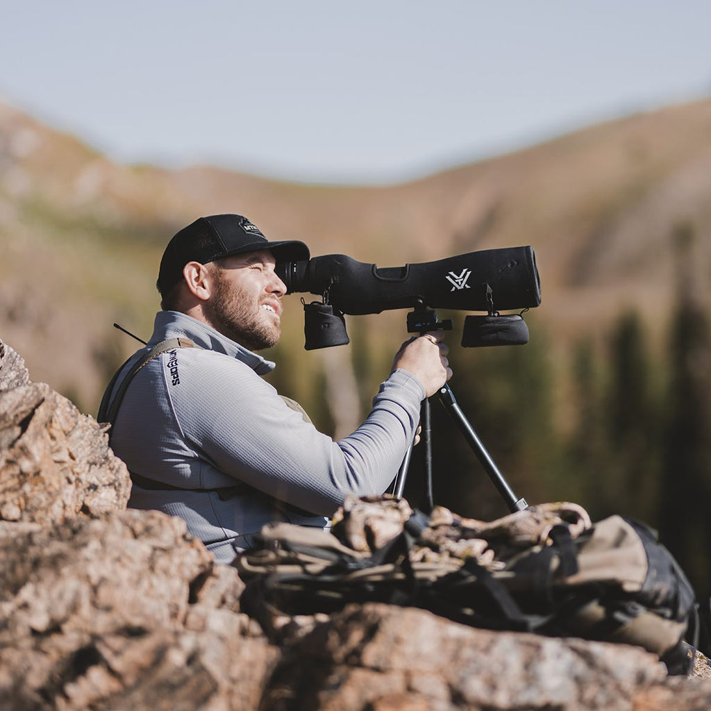 Mid Mountain Lifestyle. Man using a spotting scope in the mountains