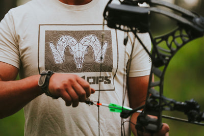Man in MTN OPS t shirt holding bow
